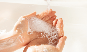 hands holding soap over a basin