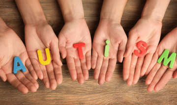 hands holding letters spelling the word autism