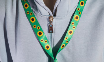 person wearing sunflower lanyard with grey top